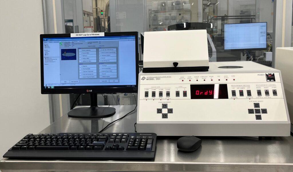 Four-point probe setup with probe head and sample stage